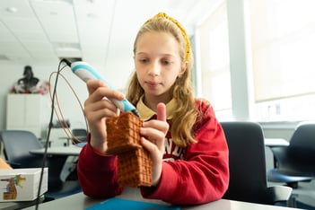 Girl in red crew sweatshirt creates ancient civilization with 3D pen