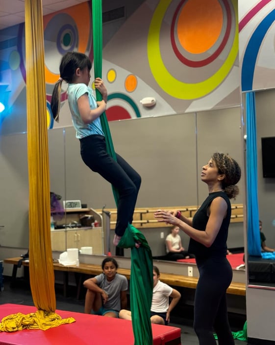 Girl on aerial silks with teacher
