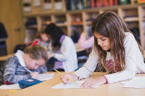 niños de la escuela básica escribiendo en la sala de clases