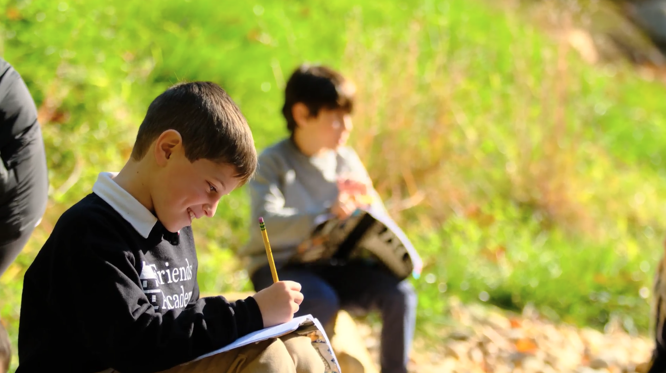 boy writing in forest