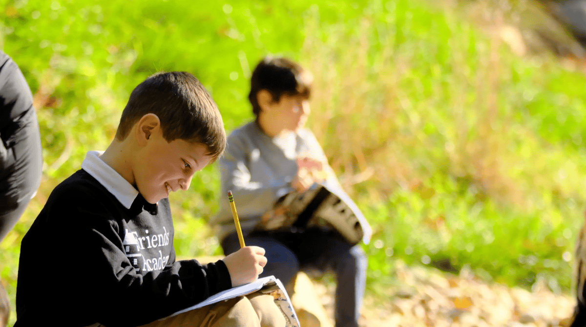 boy writing in forest