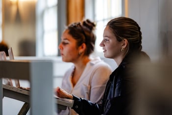 Two girls work on writing assignment about abolitionists in Quaker Meeting House