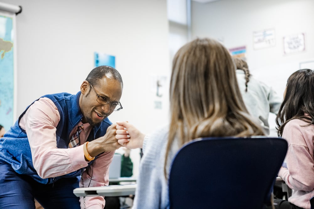 teacher fist bumping student