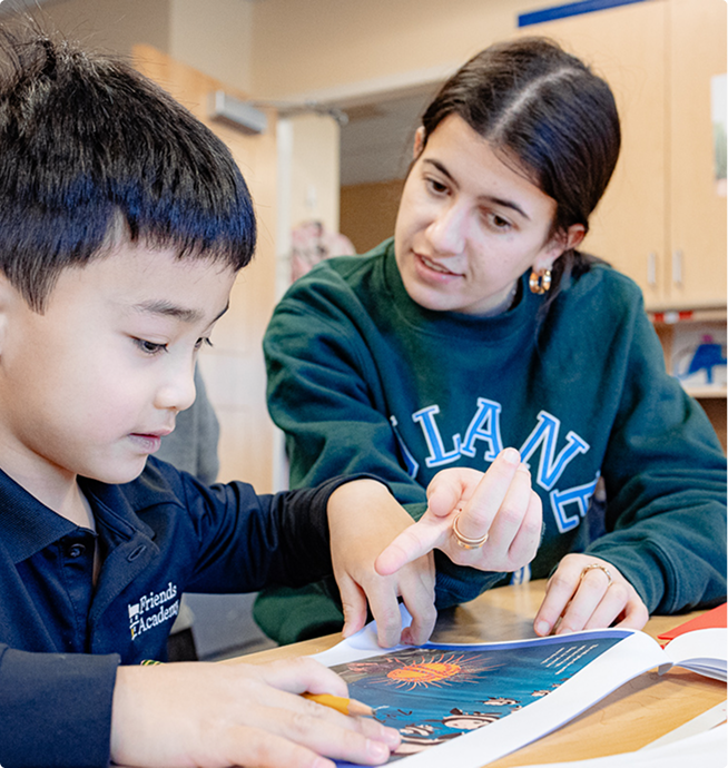 Friends Academy senior reading with a lower school student