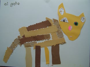 A mosaic of a cat made out of paper with the spanish word, gato
