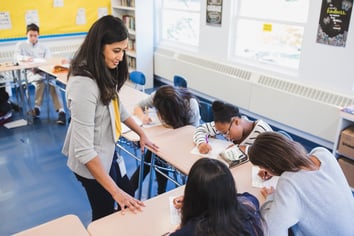 female teacher working with students at their desks