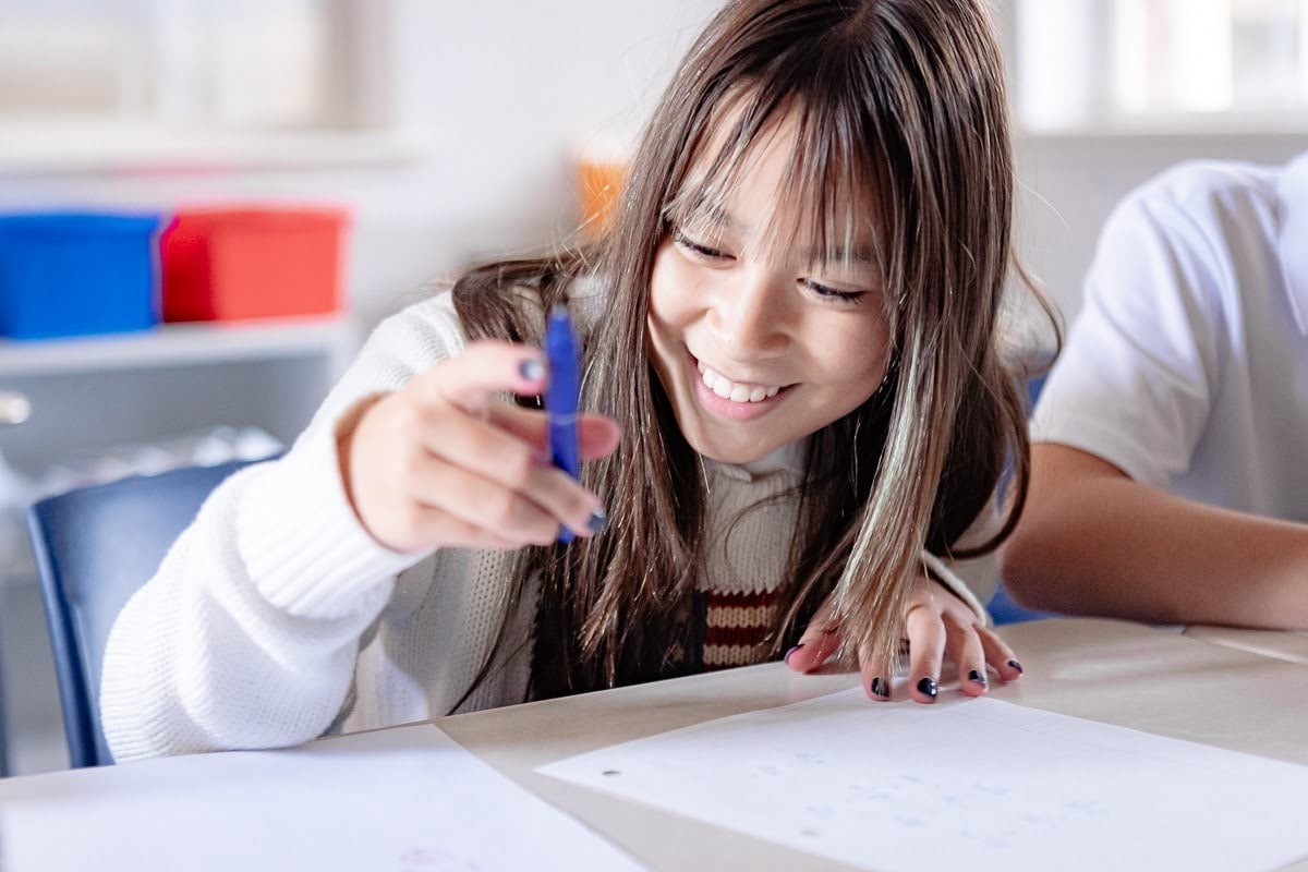 middle school girl holding a pen