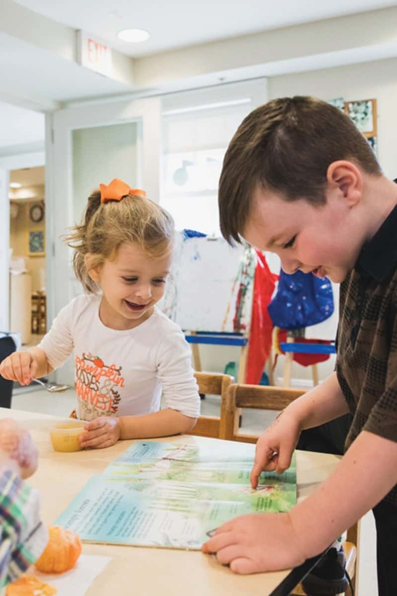 early-childhood-students-looking-at-book-min